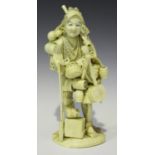 A Japanese carved ivory sectional okimono figure of a street vendor, Meiji period, modelled