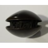 A Japanese carved hardwood clam's dream netsuke, Meiji period, the slightly open shell revealing a