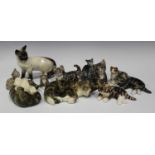 Nine Winstanley pottery cats, each with mottled decoration and glass eyes, together with a Beswick