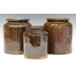A group of five Sussex slipware pottery storage jars, 19th century, each of cylindrical form,
