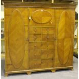 An early 20th century satinwood three-section wardrobe, the moulded pediment above a central