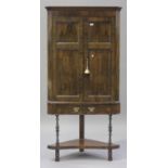 An 18th century walnut corner cupboard-on-stand, the moulded top above a pair of panelled doors