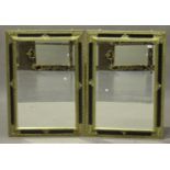 A pair of modern black and gilt painted rectangular wall mirrors with foliate moulded frames, 60cm x