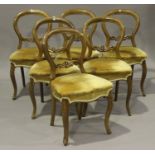 A set of six Victorian walnut balloon back dining chairs with overstuffed seats, raised on