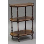 A mid-Victorian burr walnut three-tier whatnot with a gilt metal gallery, the shaped shelves on