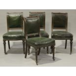 A set of four Edwardian walnut dining chairs with green leatherette seats, on turned and fluted