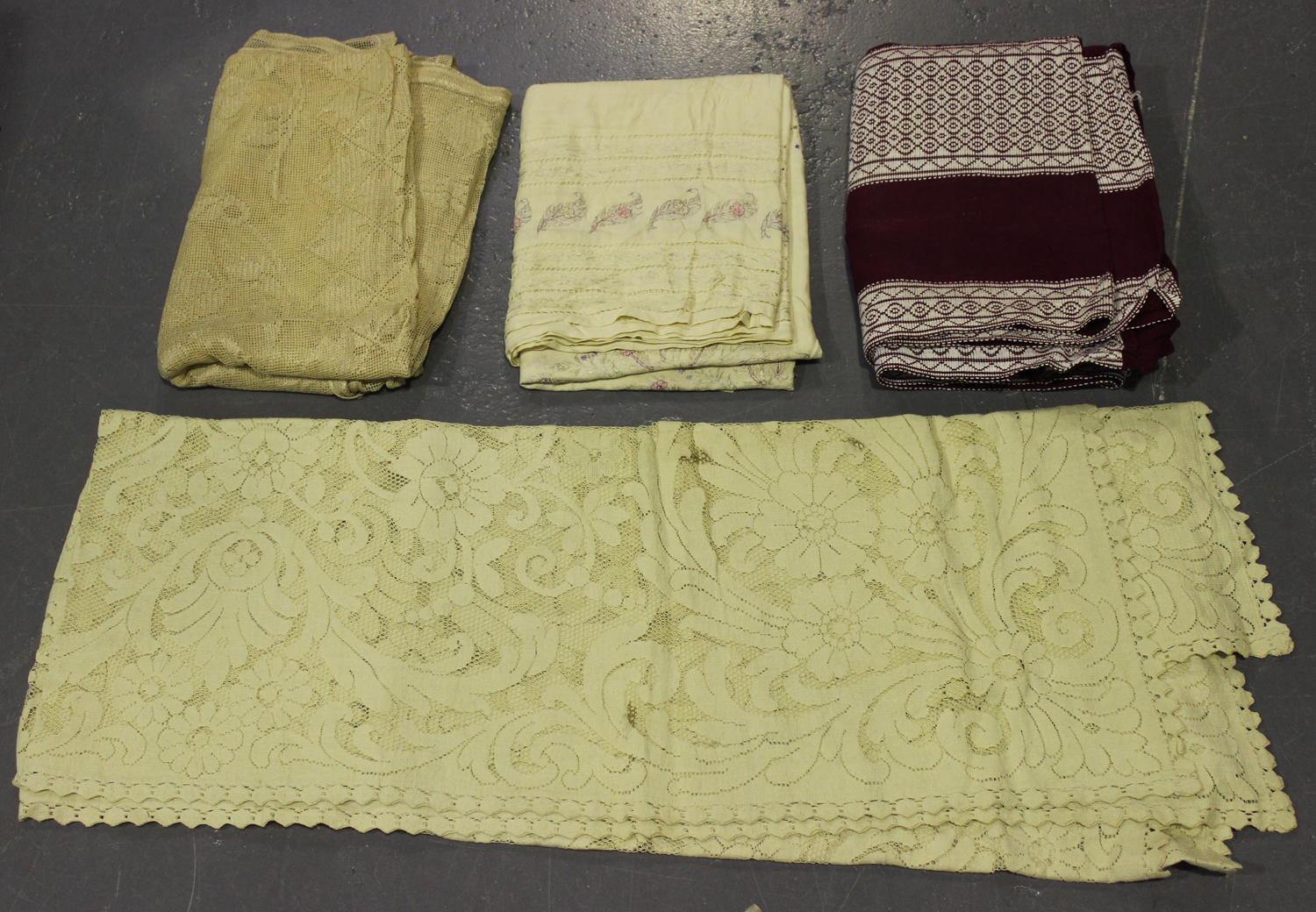 A collection of early/mid-20th century table and bed linen, including embroidered tablecloths, woven