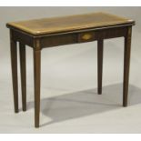 A late George III mahogany fold-over tea table with inlaid decoration, raised on square tapering