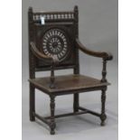 A late 19th century French oak elbow chair with carved decoration, the back with a pierced