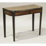 A George III mahogany fold-over tea table with a satinwood inlaid frieze, raised on moulded square