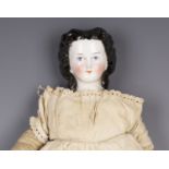 A porcelain head and shoulder doll with painted moulded features and cloth body, height 51cm (should