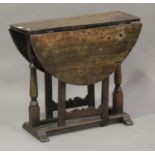 A 17th century style oak oval gateleg table, on turned and block supports united by stretchers,