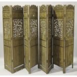 A pair of early 20th century Chinese hardwood four-fold screens, each section carved and pierced