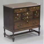 An early 20th century George III style oak chest-on-stand, fitted with an arrangement of seven