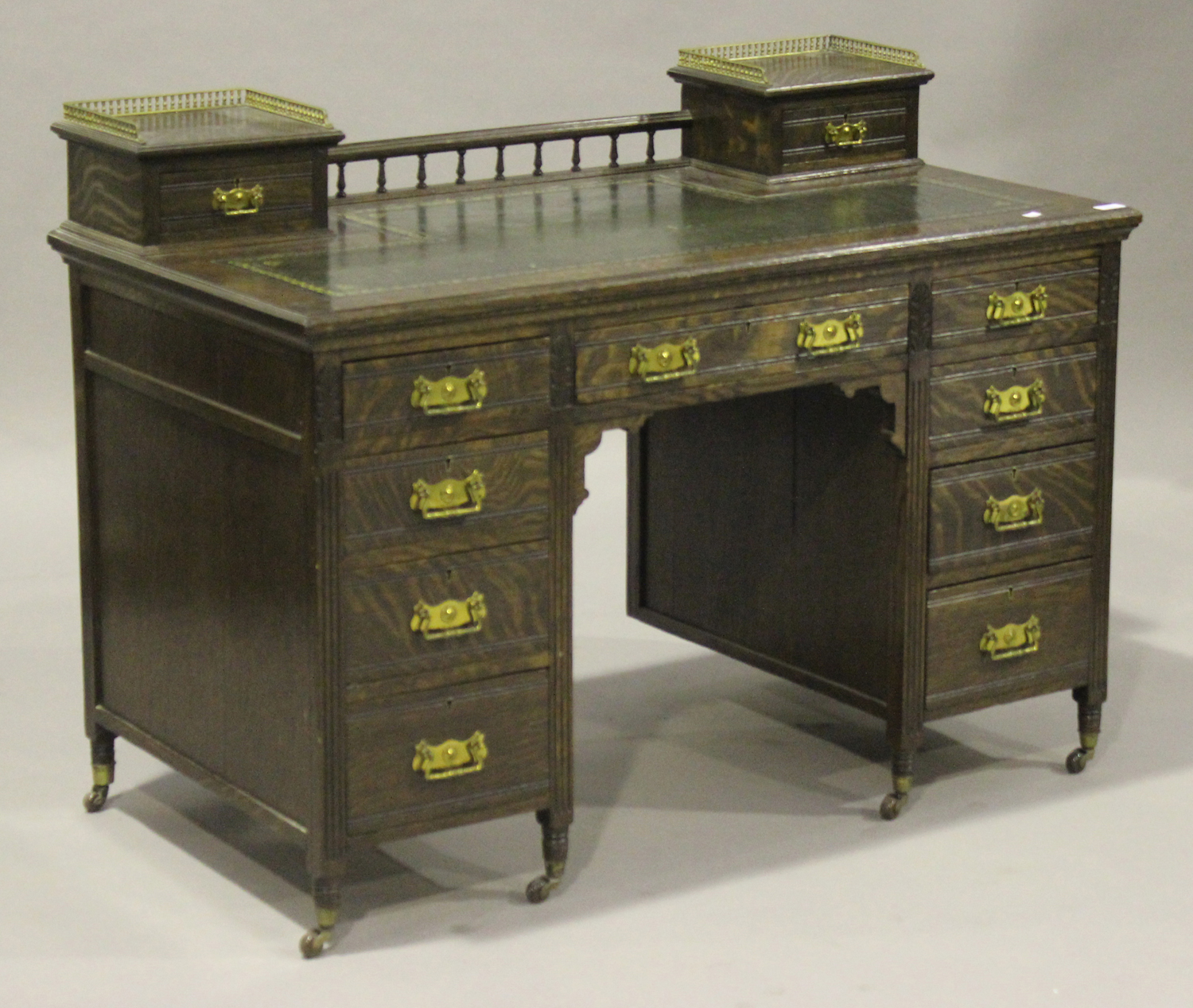 An Edwardian oak twin pedestal desk, the gallery back above a gilt-tooled green leather writing