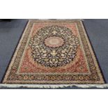 A modern machine made Kashan style rug, the dark blue field profusely decorated with palmettes and