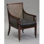 A Victorian mahogany framed bergère library armchair with green buttoned leather seat, on tapering