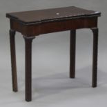 An early George III mahogany fold-over card table, the shaped top above a carved edge, raised on