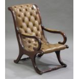 A late 20th century mahogany framed buttoned brown leather library armchair, raised on scrolling