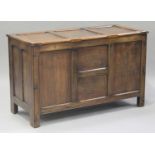 A George V oak panelled coffer, the hinged lid and panelled sides raised on stile supports, height