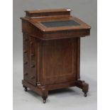 A Victorian walnut Davenport desk, the hinged writing surface above four drawers, on turned feet and