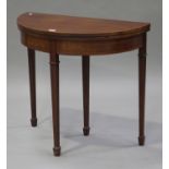 An Edwardian mahogany demi-lune fold-over card table, raised on square tapering legs, height 75cm,