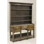 An 18th century provincial oak dresser, the moulded pediment above a shelf back, the base fitted