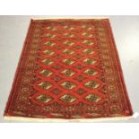 A Pakistan bokhara style rug, mid/late 20th century, the red field with three columns of guls,