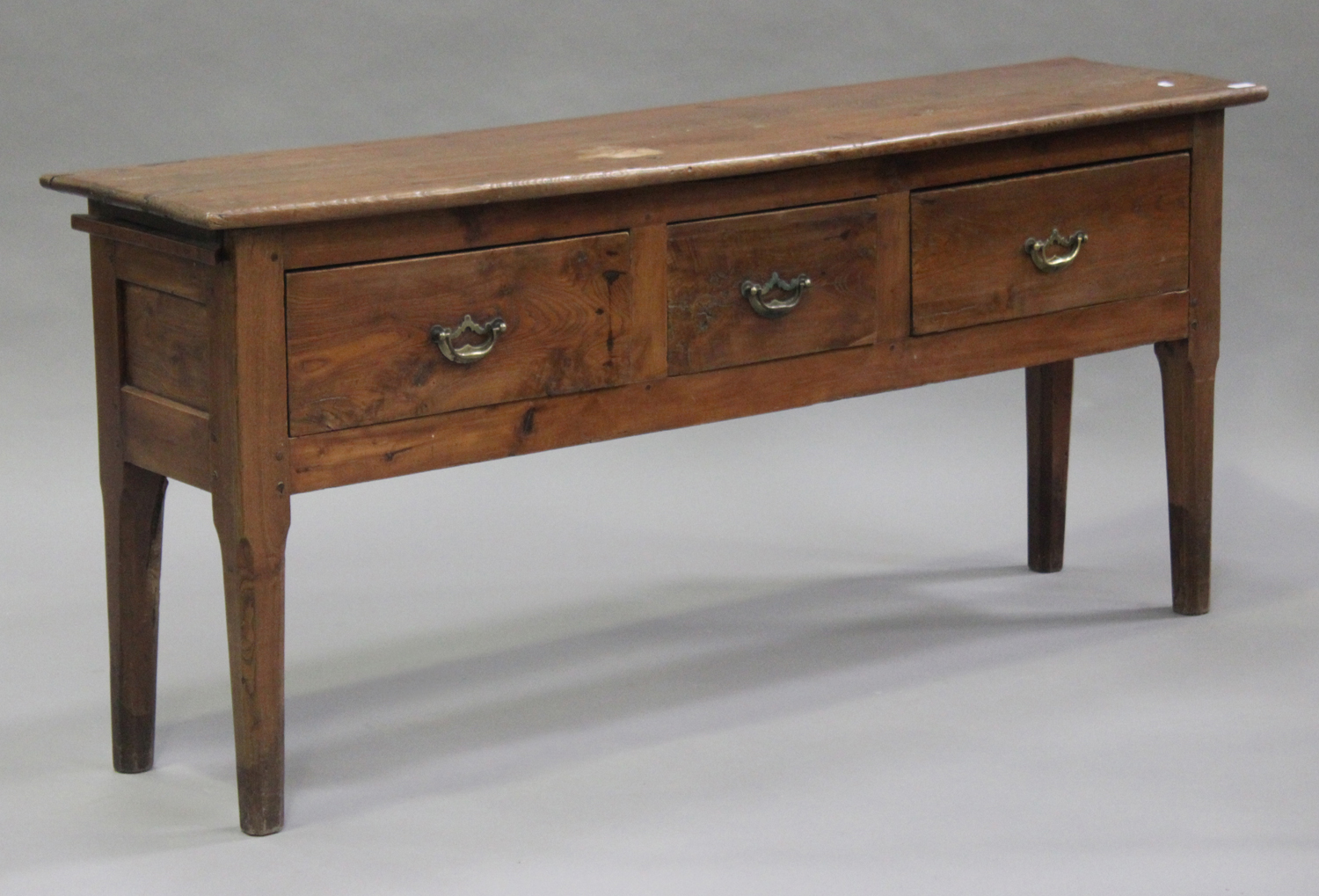 A late 19th/early 20th century French oak serving table, fitted with three drawers and an end slide,