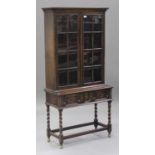 A George V Carolean Revival oak display cabinet-on-stand, fitted with a pair of astragal glazed