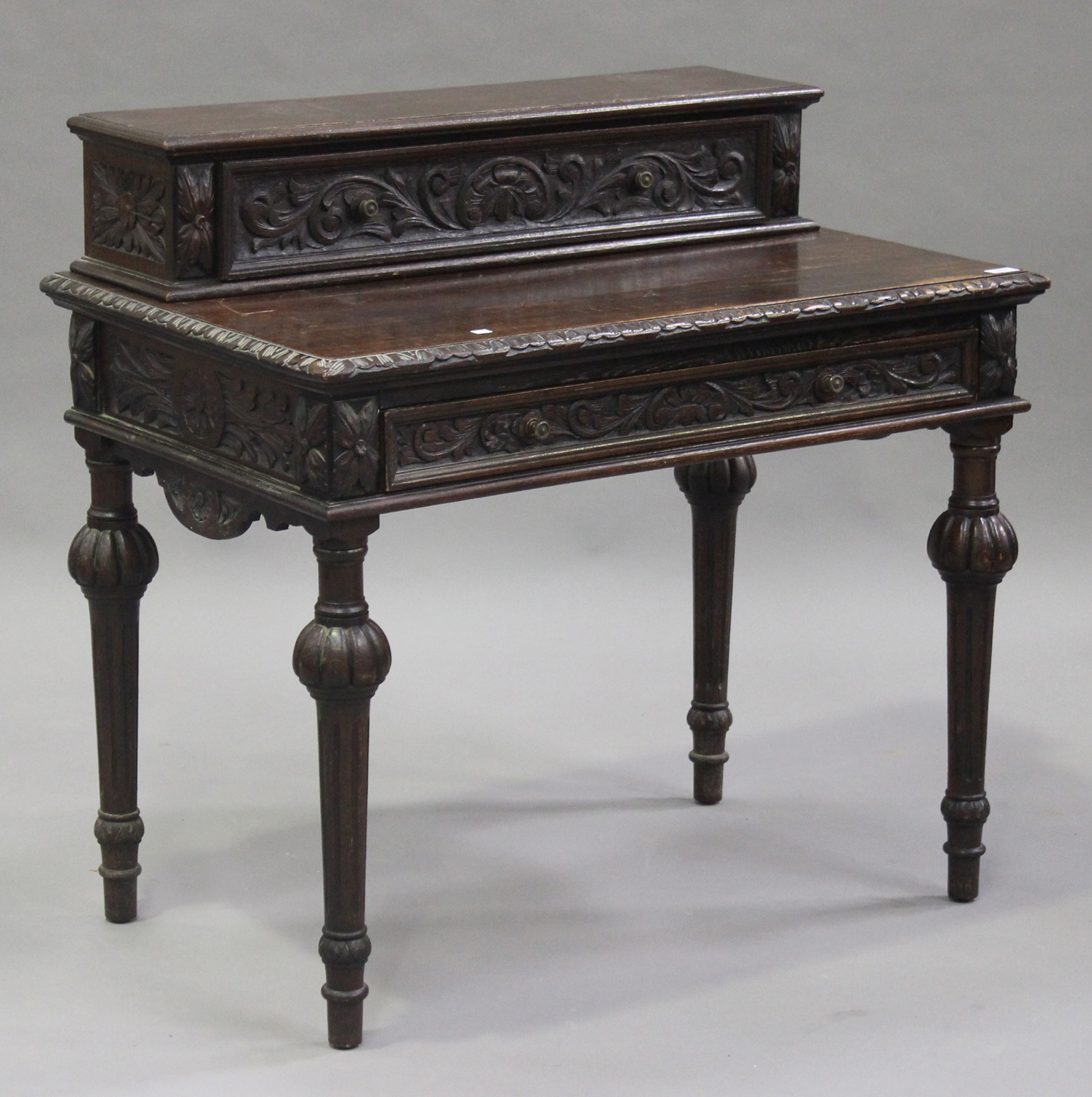 A late Victorian oak side table with carved decoration, the raised back fitted with a drawer above a