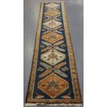 A Turkish runner, early/mid-20th century, the blue field with a column of stepped medallions