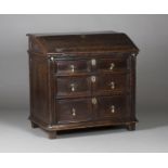 A 17th century provincial oak writing desk, the fall front revealing drawers, a well and pigeonholes