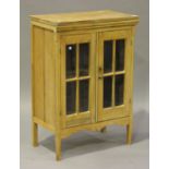 A 20th century stripped pine side cabinet, fitted with a pair of lattice glazed doors, on block