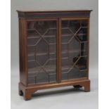 An Edwardian mahogany bookcase, the moulded top above a pair of astragal glazed doors, on bracket