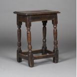 A 17th century oak joint stool, the moulded seat raised on turned and block legs united by