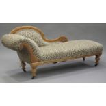 A late Victorian satin walnut framed chaise-longue, raised on turned baluster legs and castors,