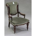 A late Victorian walnut showframe salon armchair, upholstered in green velour, on turned and