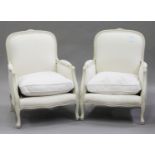 A pair of modern French style white painted showframe armchairs, upholstered in white fabric, on