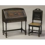 A George V oak bureau with carved decoration and applied mouldings, the fall front above a drawer,