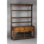 An 18th century provincial oak dresser, the shelf back with a shaped frieze fitted with wrought