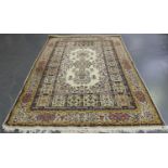 An Indian carpet, mid-20th century, the ivory field with a floral medallion and sprays, within a