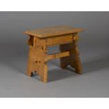 A 20th century Arts and Crafts style oak joint stool, the moulded seat raised on trestle supports