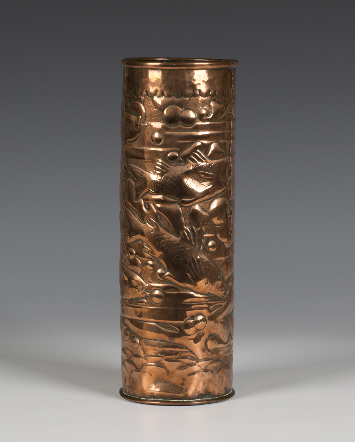 An Arts and Crafts Newlyn copper cylindrical vase, the body worked with a scene of five fish