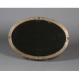 An early 20th century Arts and Crafts style copper and brass oval wall mirror with a bevelled