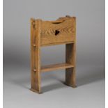 A 20th century Arts and Crafts style oak magazine rack of pegged construction, fitted with a