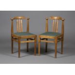 A pair of Edwardian Cotswold style oak rail back side chairs, the curved top rails above drop-in