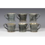 Six Walter (Wally) Keeler salt-glazed stoneware mugs, each covered in a speckled blue/grey glaze and