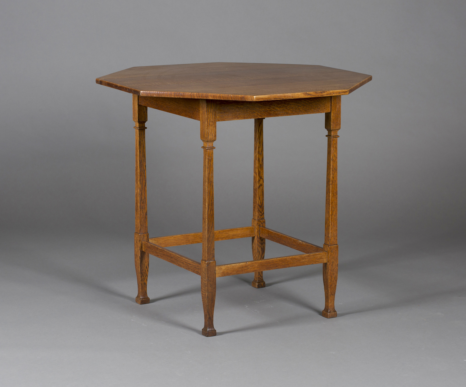 An Edwardian Arts and Crafts oak octagonal occasional table by Shapland & Petter, raised on square