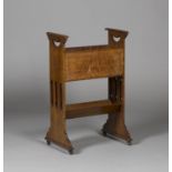 An Edwardian Arts and Crafts oak magazine/book rack, possibly Glasgow School, the shaped and pierced